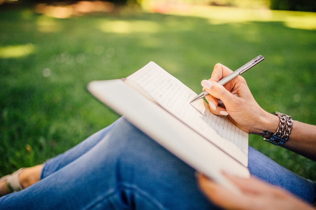 writer outside, writing in journal