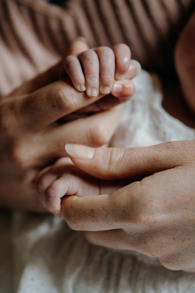 mother and baby hands on brown background