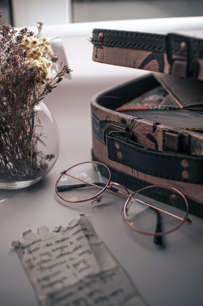 memoir image vintage suitcase with journal inside, note outside, vintage glasses