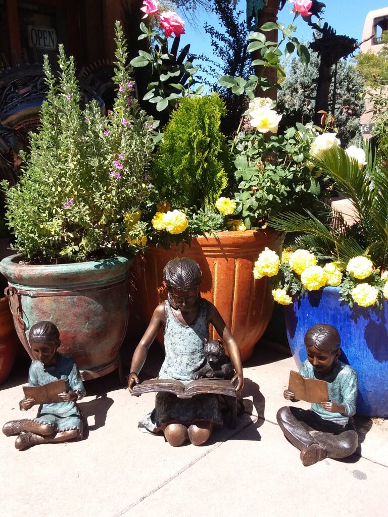 Sculpture - Santa Fe children Garden scene in Santa Fe, sculptures of children reading surrounded by pots of flowers