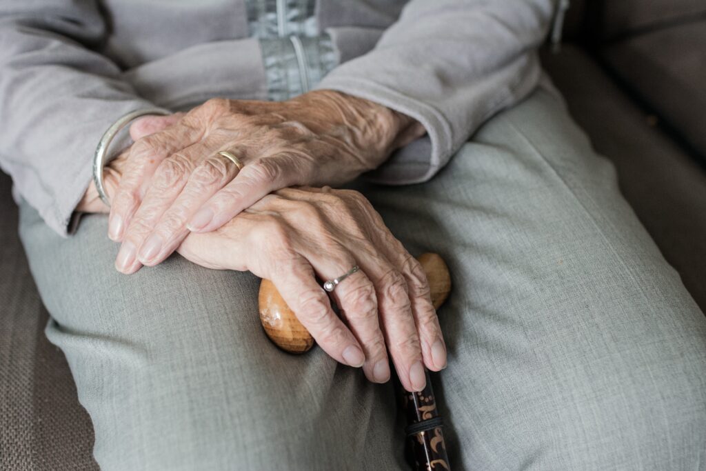 old person Older person, hands in lap, gripping cane